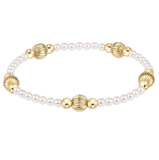 Bracelet with alternating gold and pearl beads on a white background