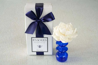 Gift box with a blue ribbon and a decorative flower on a light gray background