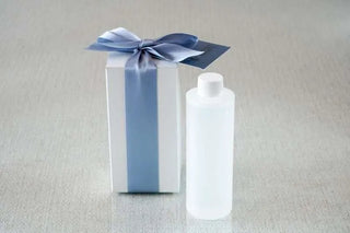 White bottle with a blue ribbon on a gray background
