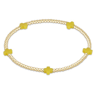 Gold bracelet with yellow clover-shaped charms on a white background