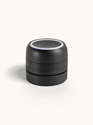 Black cylindrical container with a white lid on a white background