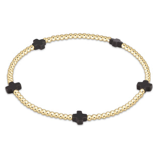 Gold bracelet with black cross beads on a white background