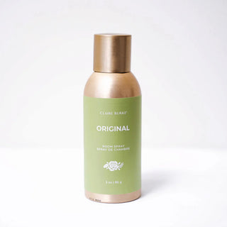 Body spray bottle with gold cap and green label on a white background