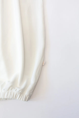 Close-up of a white satin pillowcase on a white background