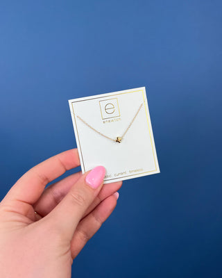 Enewton Small Gold Signature Cross Necklace featuring a polished petite gold cross centered on a delicate 16-inch gold chain