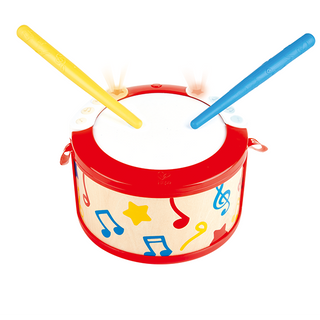 Toy drum with red top and blue and yellow sticks on a white background