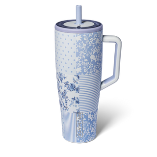 Blue floral-patterned tumbler with a handle on a white background