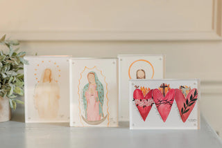 Set of four framed artworks on a shelf with a neutral background