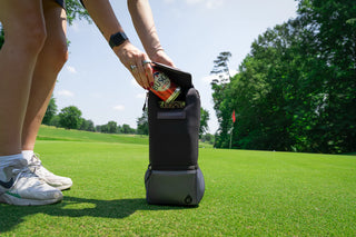 Person on a golf course with a caddy holding drinks
