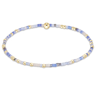 Enewton Hope Unwritten Bloopers Blue White and Gold Bracelet displayed on a solid blue background. 