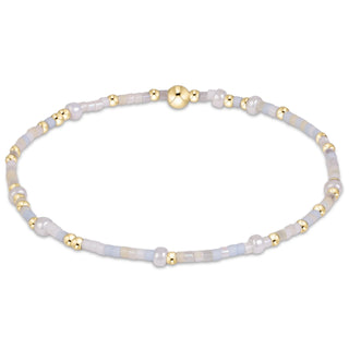 Enewton Hope Unwritten Daydreaming Bracelet displayed on a wrist on a solid blue background. 