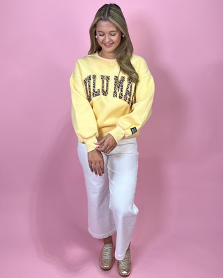 Woman wearing a yellow sweatshirt with text on a pink background