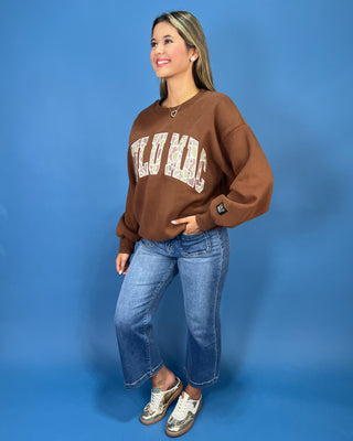a brown crewneck sweatshirt with LULU MAC on sweatshirt.
