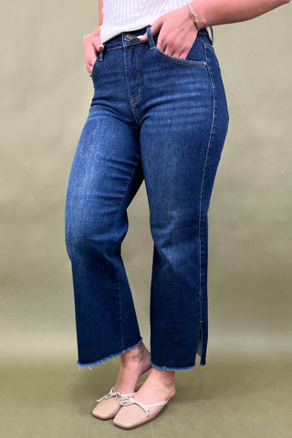 Person wearing blue jeans on a plain background