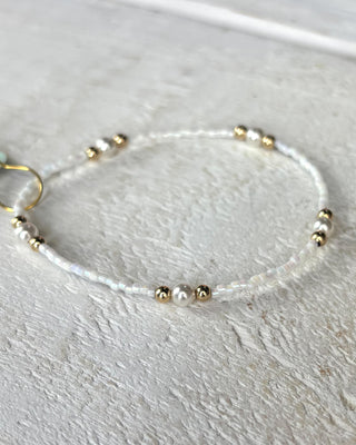 Beaded bracelet with gold and silver beads on a light gray background
