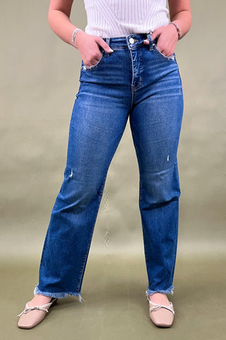 Person wearing blue jeans on a plain background