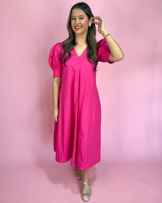 Woman wearing a pink dress against a pink background