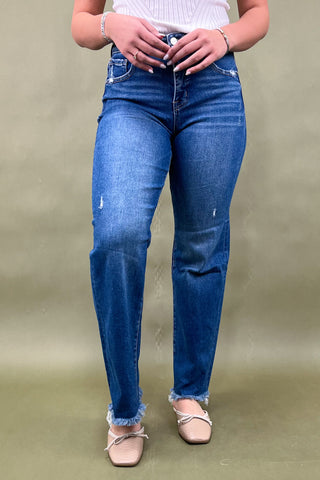 Person wearing blue jeans on a plain background