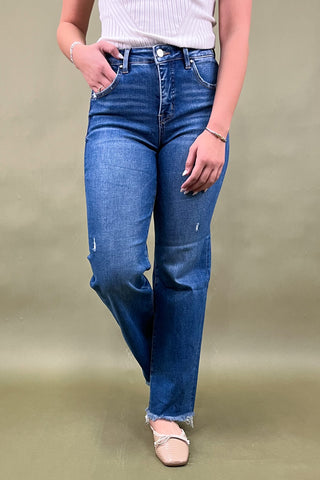 Person wearing blue jeans on a plain background