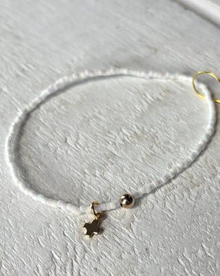 Necklace with small charms on a light gray surface