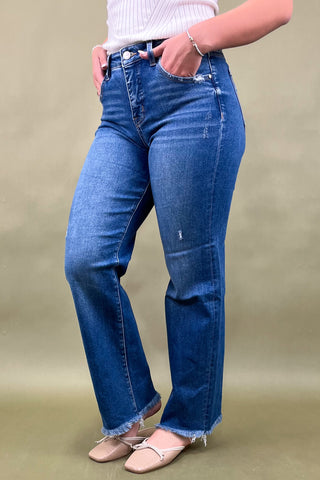 Person wearing blue jeans on a beige background