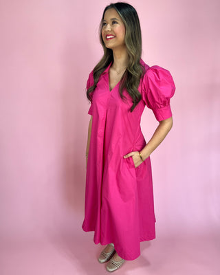 Woman wearing a bright pink dress against a pink background