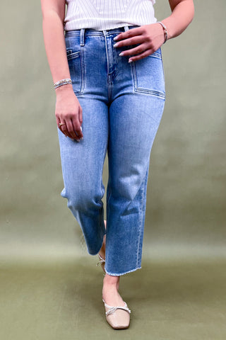 Person wearing light blue jeans on a plain background