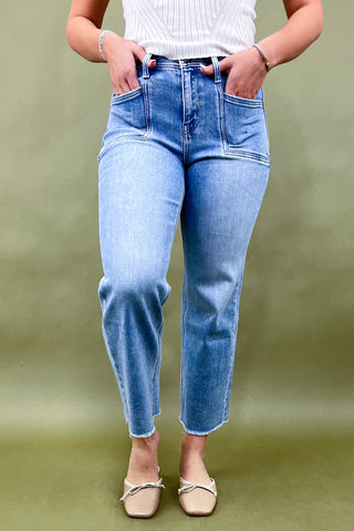 Person wearing light blue jeans on a green background