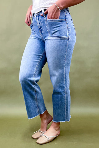 Person wearing light blue jeans on a green background