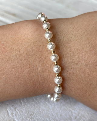 Pearl bracelet on a wrist with a white background