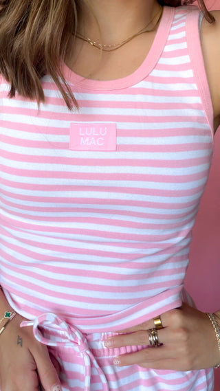 A close-up of a person wearing a pink and white striped sleeveless top with a small pink chest patch reading 'LULU MAC'.
