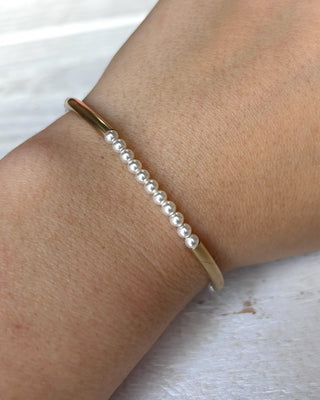 Pearl bracelet on a wrist with a light background