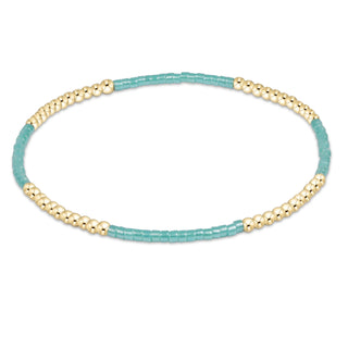 Beaded bracelet with gold and turquoise beads on a white background
