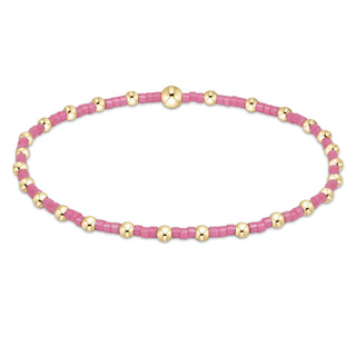 Bracelet with pink and gold beads on a white background