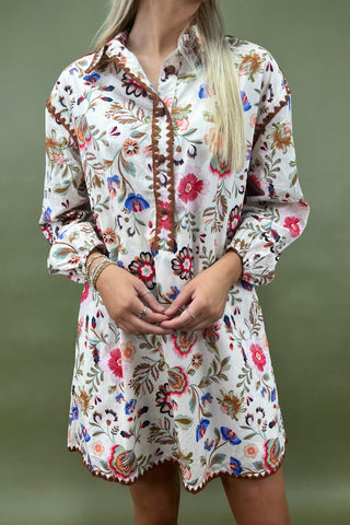 Woman wearing a floral dress with a blurred green background