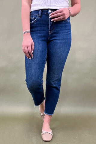 Person wearing blue jeans on a plain background