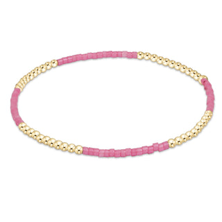 Bracelet with pink beads and gold accents on a white background