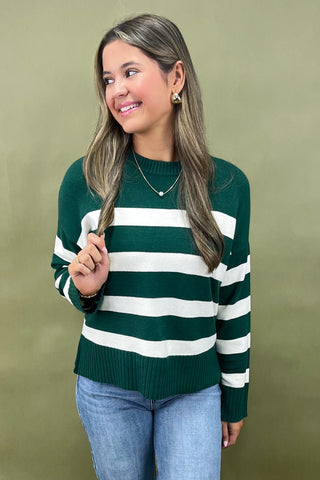 Green and white striped knit sweater styled with light wash wide leg frayed hem jeans and gold loafers