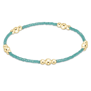 Turquoise bracelet with gold beads on a white background
