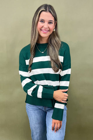 Green and white striped knit sweater styled with light wash wide leg frayed hem jeans and gold loafers