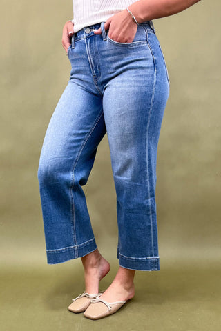 Person wearing blue jeans on a green background