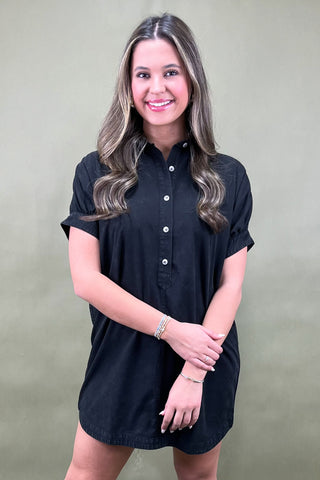 Woman wearing a black dress against a plain background