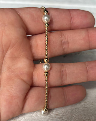Gold and pearl bracelet on a hand