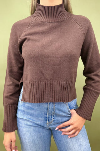 Chocolate brown mock neck sweater styled with light wash wide leg frayed hem jeans and gold loafers