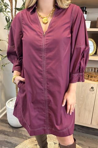 Person wearing a purple dress with a blurred background