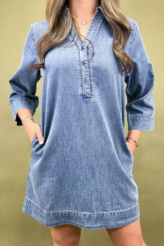 Blue denim dress worn by a person on a beige background