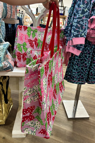 Colorful patterned bags with red handles displayed in a store setting.