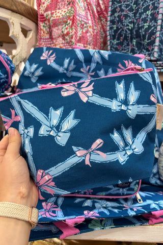 Blue pouch with floral design held by a hand