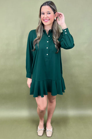 Woman wearing a green dress against a plain background