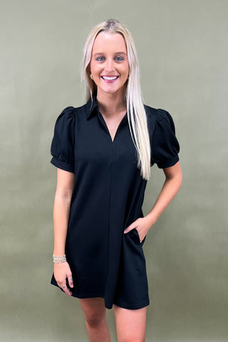 Woman wearing a black dress against a green background